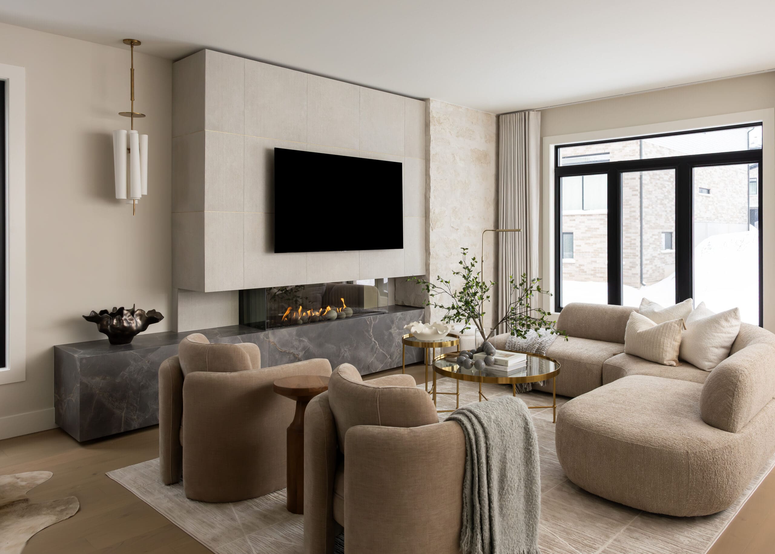Modern living room in the Ritz Homes Vista Hills model home with fireplace, built-in media wall, and large windows